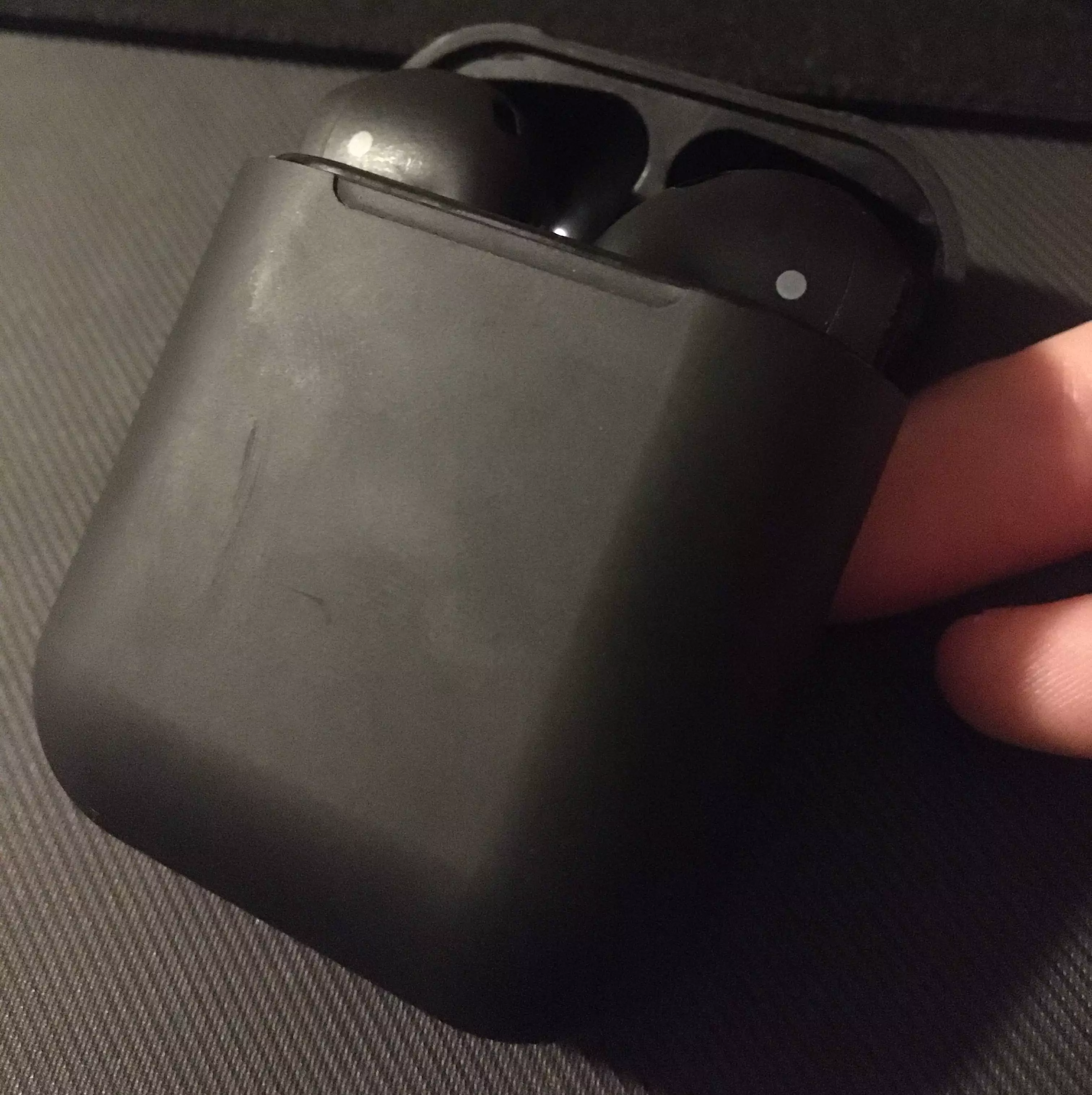 AirPods held slightly tilted with the case lid opened to expose the head of the pods